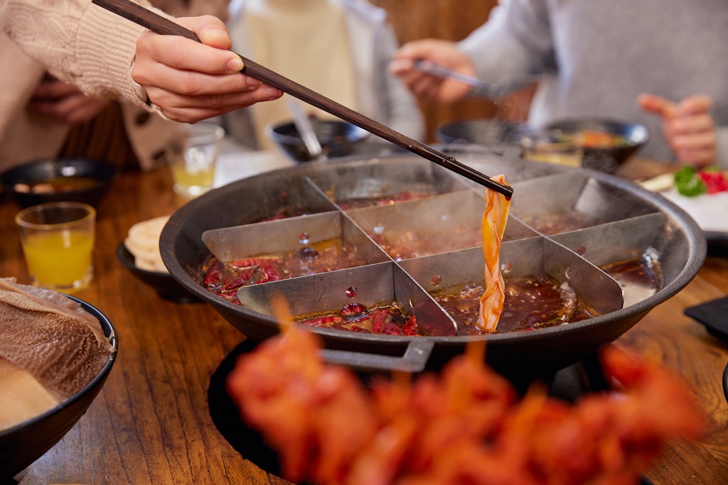 1772761076998558.jpg 火锅店吃重庆火锅夹菜特写(企业商用).jpg